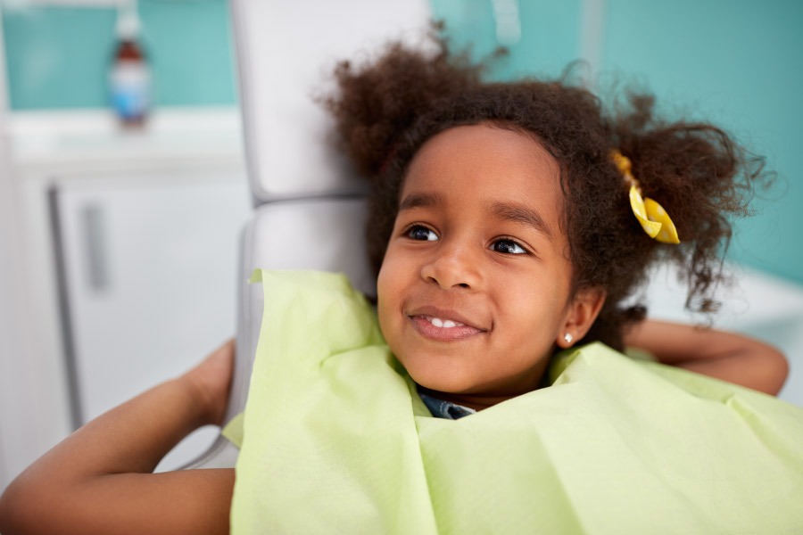 Smiling girl sitting in the dental chair  dental crown.